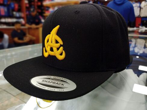 قبعة PeligroSports Aguilas Cibaeñas SnapBack سوداء مع شعار ذهبي أصفر in Saudi Arabia