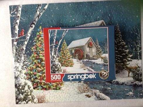 Springbok The Falling Snow 500 Piece Jigsaw Puzzle for Adults Features a Holiday Cabin Glowing in The Snow with a Decorated Christmas Tree Beside it in Saudi Arabia