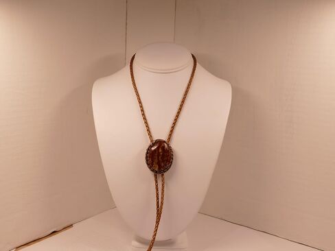 A Deep Red and Gold Jasper Cabochon is in a Copper Tone Bolo Slide with Copprt Tone Leather Cord and Swirl Tips in Saudi Arabia