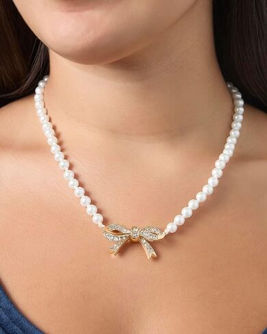 عقد من Juicy Couture مزين بفيونكة من اللؤلؤ الصناعي وأحجار شفافة، عقد بقلادة على شكل فيونكة ذهبية اللون مقاس 18 بوصة + 2 بوصة in Kuwait