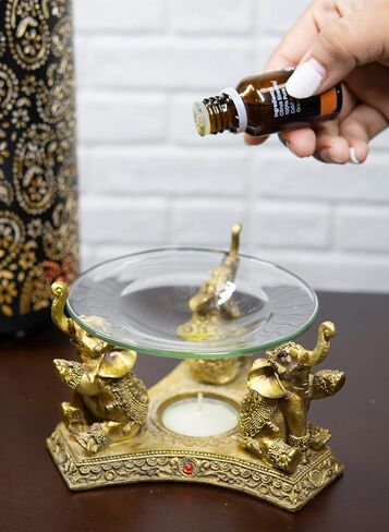 Ebros Feng Shui Trio Golden Tooled Thai البوذية الفيلة البوق ضوء الشاي شمعة النفط دفئا تمثال الشمع تورتة الموقد رائحة الناشر الراتنج بوذا الفيل تحت عنوان تمثال الزخرفية in Kuwait