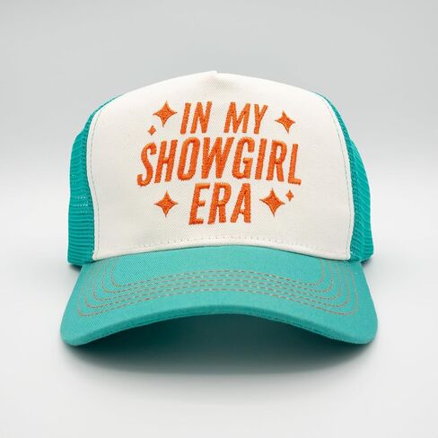 قبعة سائق الشاحنة باللون الأزرق المخضر والأبيض مع نص برتقالي لامع في نص My Showgirl Era، وخياطة متباينة، وقبعة بيسبول بموضوع الحفل الموسيقي in Saudi Arabia