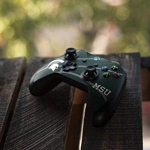 ملصق Skinit المخصص للألعاب متوافق مع وحدة تحكم Xbox One X - تصميم كرة السلة الأخضر لجامعة ولاية ميشيغان المرخص رسميًا in Kuwait