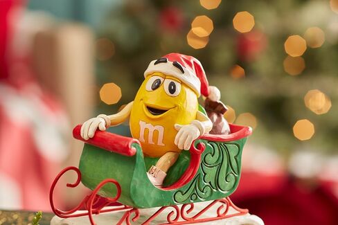 Enesco M&M's by Jim Shore M&M شخصية صفراء تركب في مزلقة - تمثال حلوى M&M مطلي يدويًا من الراتنج الحجري لديكور المنزل في عيد الميلاد، 5.71 بوصة in Saudi Arabia