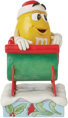 Enesco M&M's by Jim Shore M&M شخصية صفراء تركب في مزلقة - تمثال حلوى M&M مطلي يدويًا من الراتنج الحجري لديكور المنزل في عيد الميلاد، 5.71 بوصة in Saudi Arabia