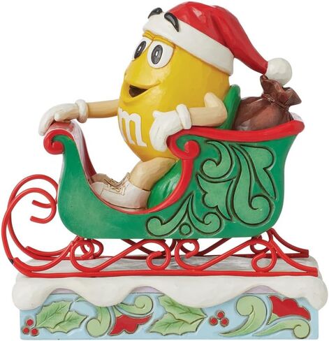 Enesco M&M's by Jim Shore M&M شخصية صفراء تركب في مزلقة - تمثال حلوى M&M مطلي يدويًا من الراتنج الحجري لديكور المنزل في عيد الميلاد، 5.71 بوصة in Saudi Arabia
