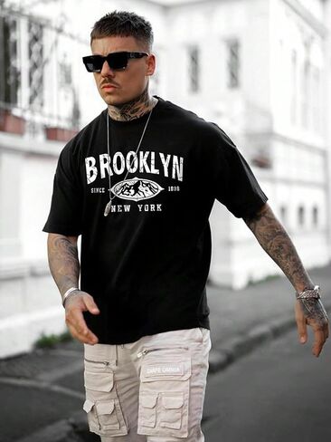 تي شيرت رجالي من SweatyRocks برسوم جرافيك وأكمام قصيرة ورقبة دائرية وكتف منسدل in Kuwait