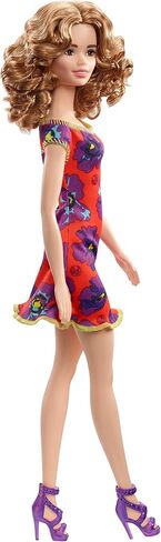 Barbie GBK92 Doll ، امرأة سمراء Auburn Curly Light ترتدي فستان أزهار أحمر وأرجواني in Saudi Arabia