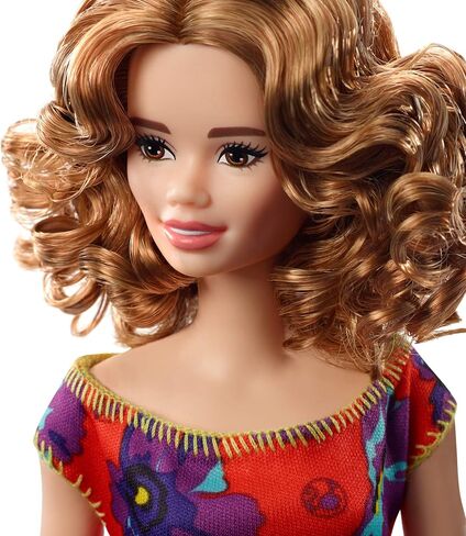 Barbie GBK92 Doll ، امرأة سمراء Auburn Curly Light ترتدي فستان أزهار أحمر وأرجواني in Saudi Arabia